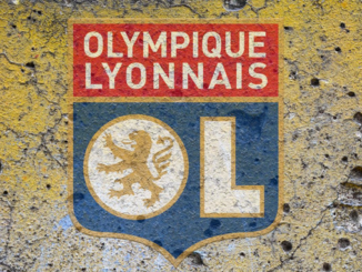 Logo de l'Olympique Lyonnais sur un mur criblé de trous et de lézardes.